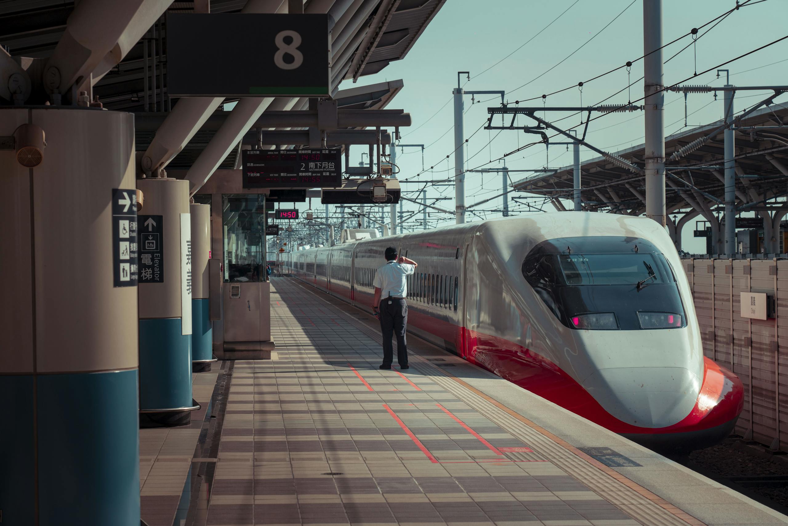 Anonymous man standing on railway station platform near contemporary train